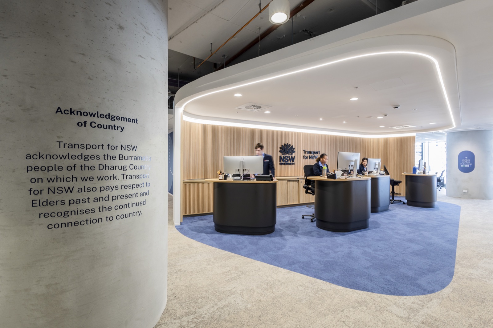 Transport for NSW reception with curved feature ceiling, timber slat wall and Acknowledgement of Country graphic
